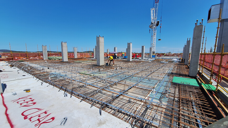 Workers install steel reinforcement and concrete columns on an upper level of the Princess Alexandra Hospital expansion site.