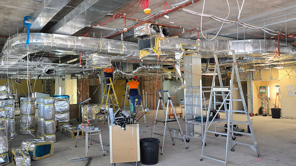 Construction workers install ducting and services inside the new Rockhampton Mental Health facility.